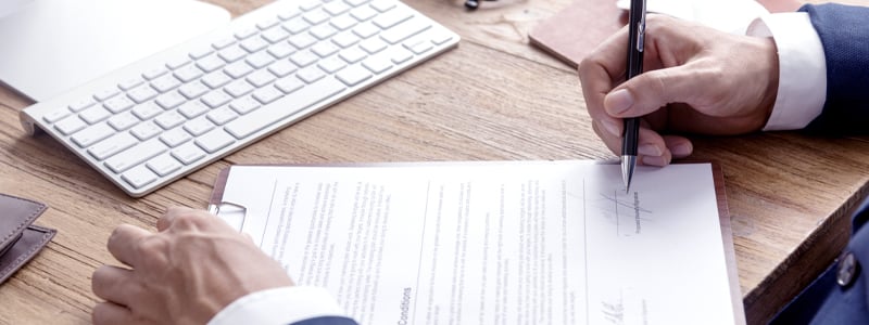 Man signing documents at desk